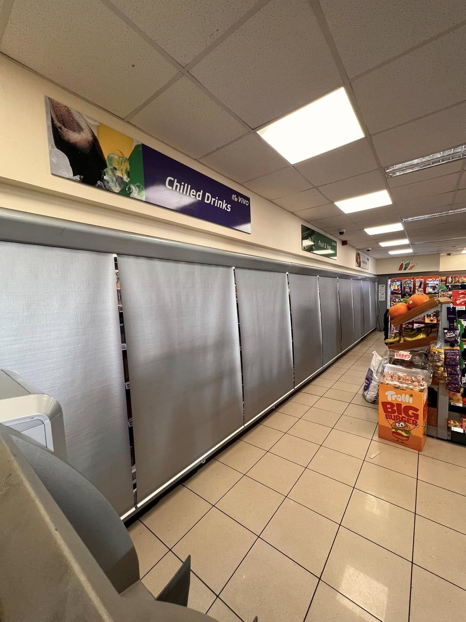 Night blinds pulled down over chilled cabinets in a shop